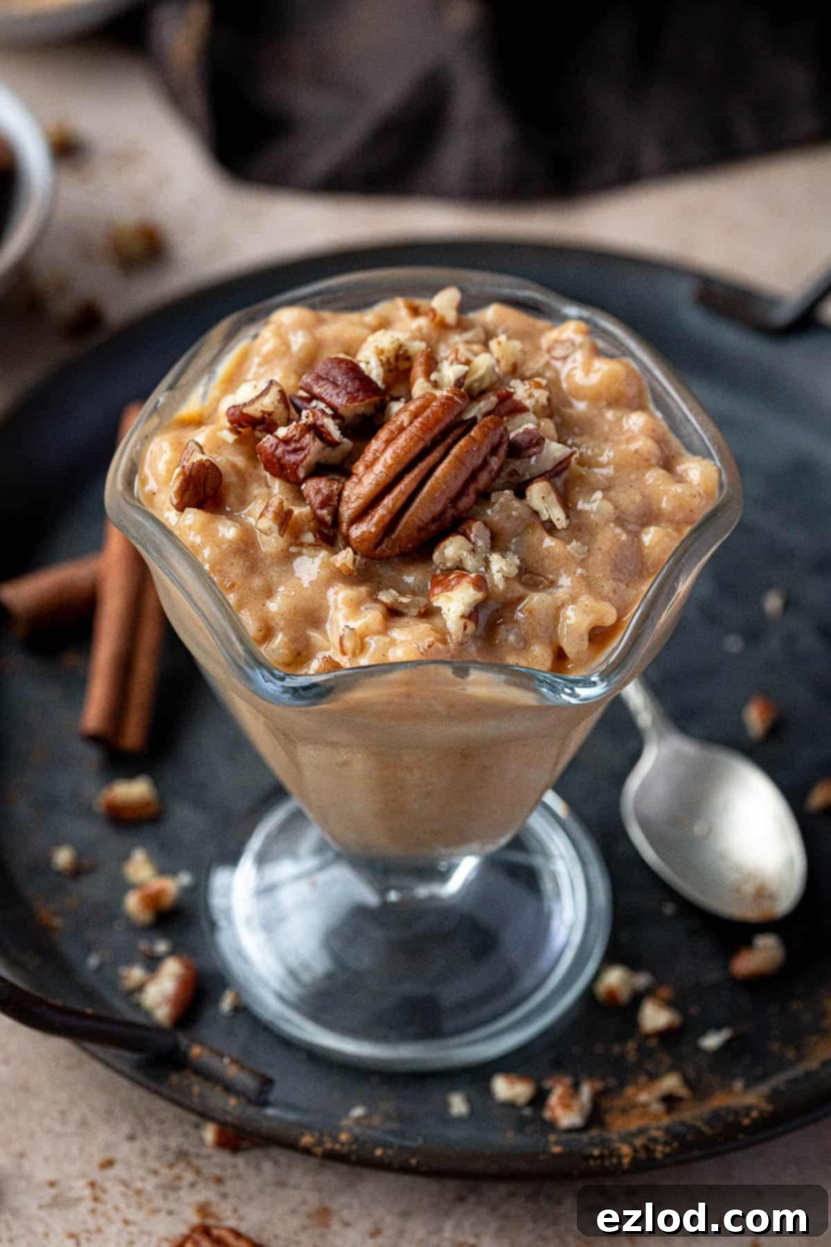 A glass of pumpkin rice pudding topped with pecans.