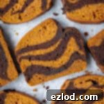 Slices of pumpkin chocolate marble bread on a sheet of baking parchment.