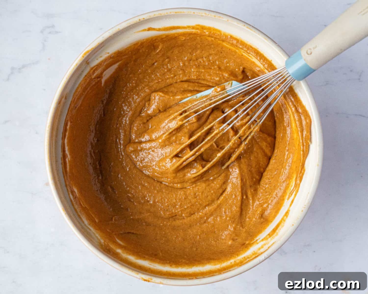 Step-by-step image showing the fully mixed pumpkin batter in a bowl, smooth and ready for the next stage.