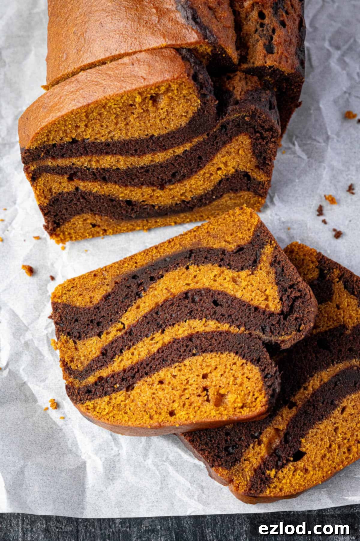 Close-up photograph of a single slice of vegan chocolate pumpkin marble cake, highlighting the contrast and moist texture.