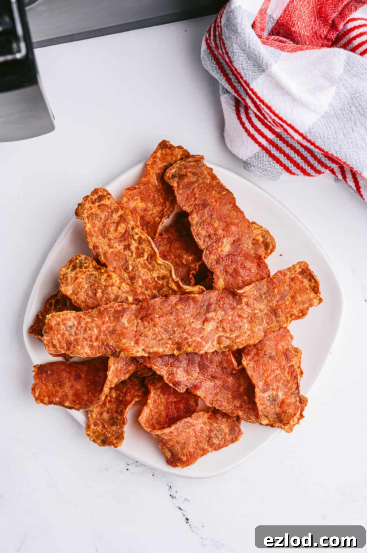Crispy Air Fryer Turkey Bacon 6 A plate of crispy turkey bacon on a white marble surface.