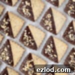 Rows of vegan hazelnut shortbread cookies on a sheet of baking parchment.