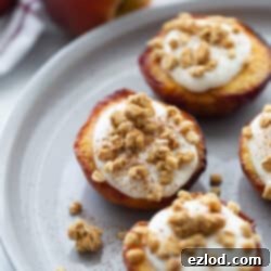 Sweet Air Fried Peaches with Creamy Ricotta 9 Three air fried peach halves on a white plate topped with whipped ricotta cinnamon and granola