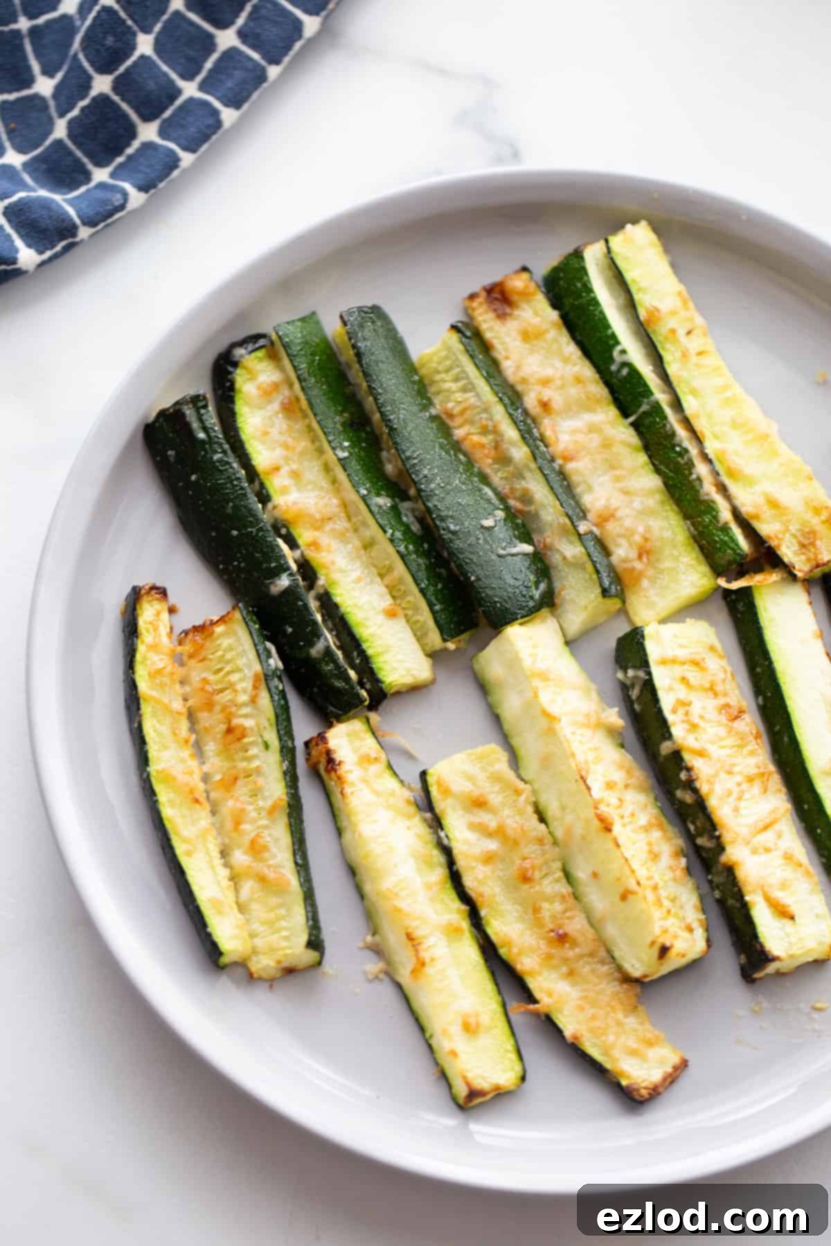 A plate of zucchini fries topped with crispy parmesan cheese
