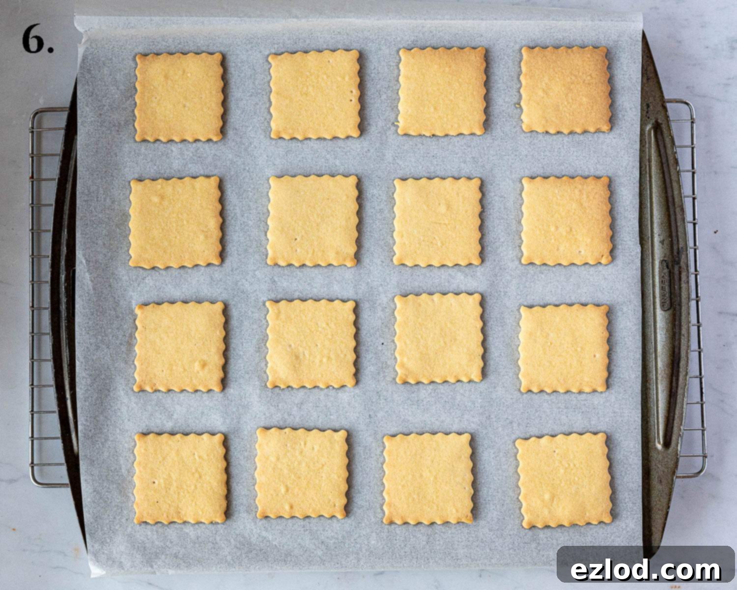 Step 6 in making vegan custard creams: the baked biscuits, golden and crisp, cooling on a wire rack after being removed from the oven.