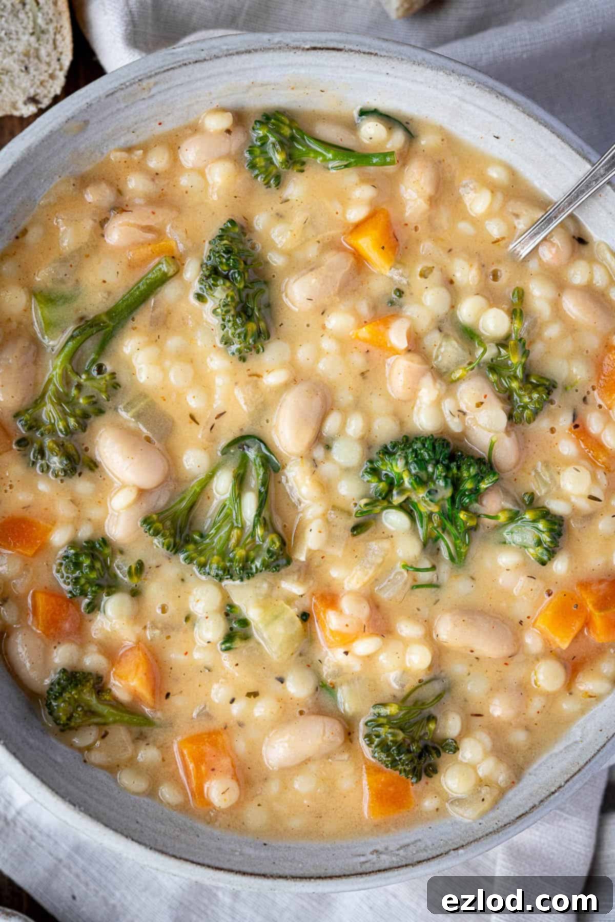 Velvety Vegan Pearl Couscous Soup 10 Close up of a bowl of vegan creamy pearl couscous soup, with steam rising, invitingly presented.