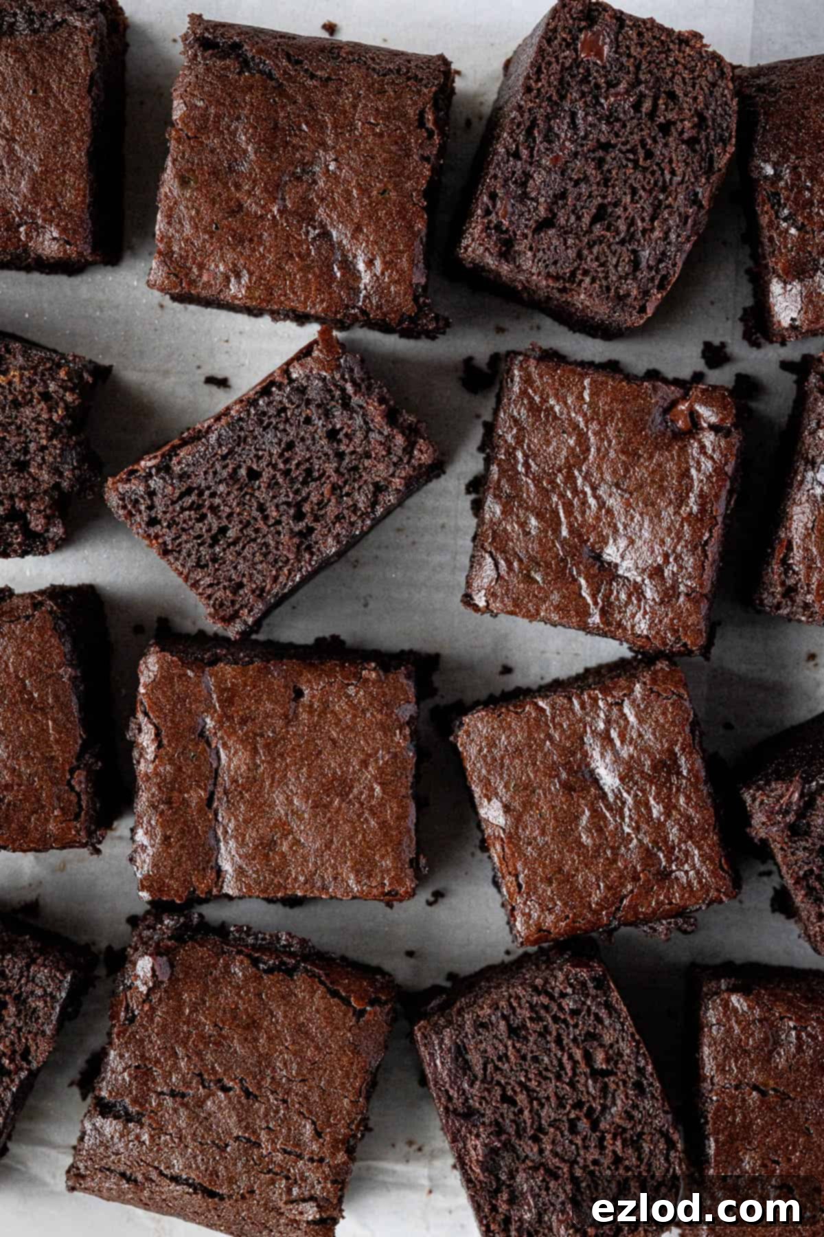 Decadent Vegan Chocolate Gingerbread Cake 4 Squares of vegan chocolate gingerbread artfully arranged on a sheet of baking parchment.