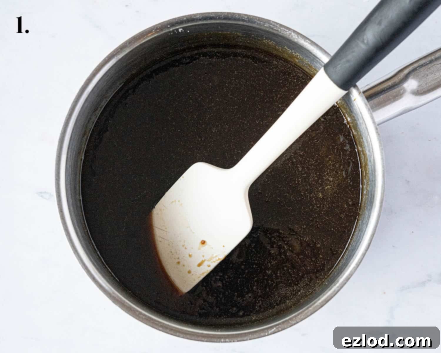 Step 1 in the baking process: a close-up of the melted wet ingredients, including syrups, butter, and sugars, shimmering in a pan.