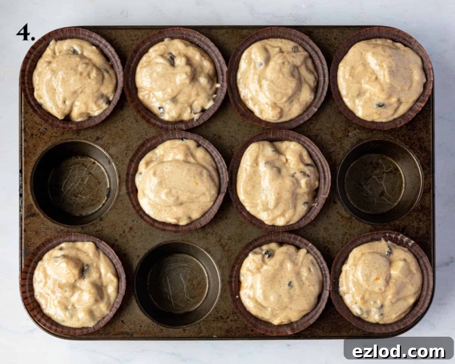 Festive Vegan Stollen Muffins 8 Step 4: The muffin batter is divided evenly into paper cases, filling them generously before baking.