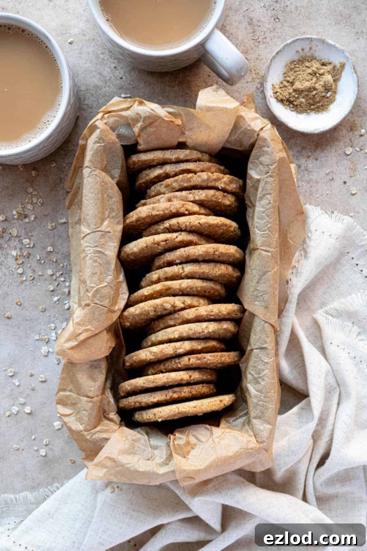 Spiced oat biscuits in a parchment lined loaf tin with cups of tea.