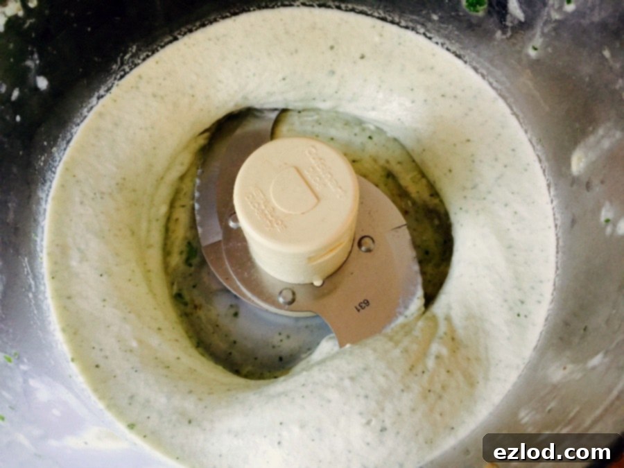 Creamy banana ice cream being blended in a food processor, showing the smooth texture it achieves.