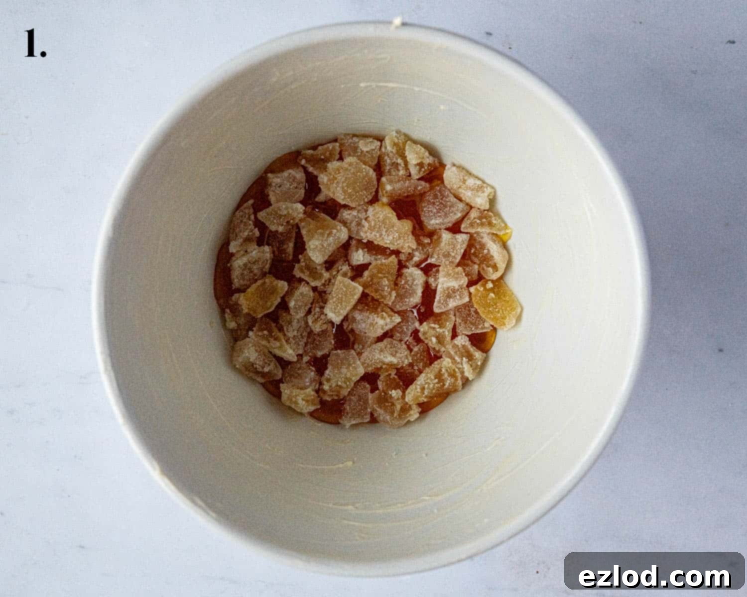 Step 1, showing chopped ginger and golden syrup at the bottom of the pudding basin.