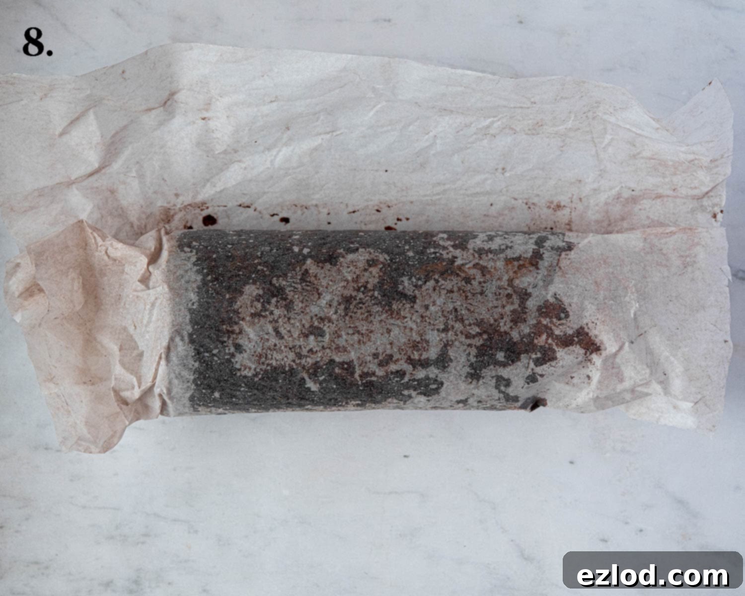 Plant-Based Chocolate Yule Log 12 Step 8: The cake, with its buttercream filling, has been tightly rolled into a spiral and is now wrapped in baking paper, ready for chilling.
