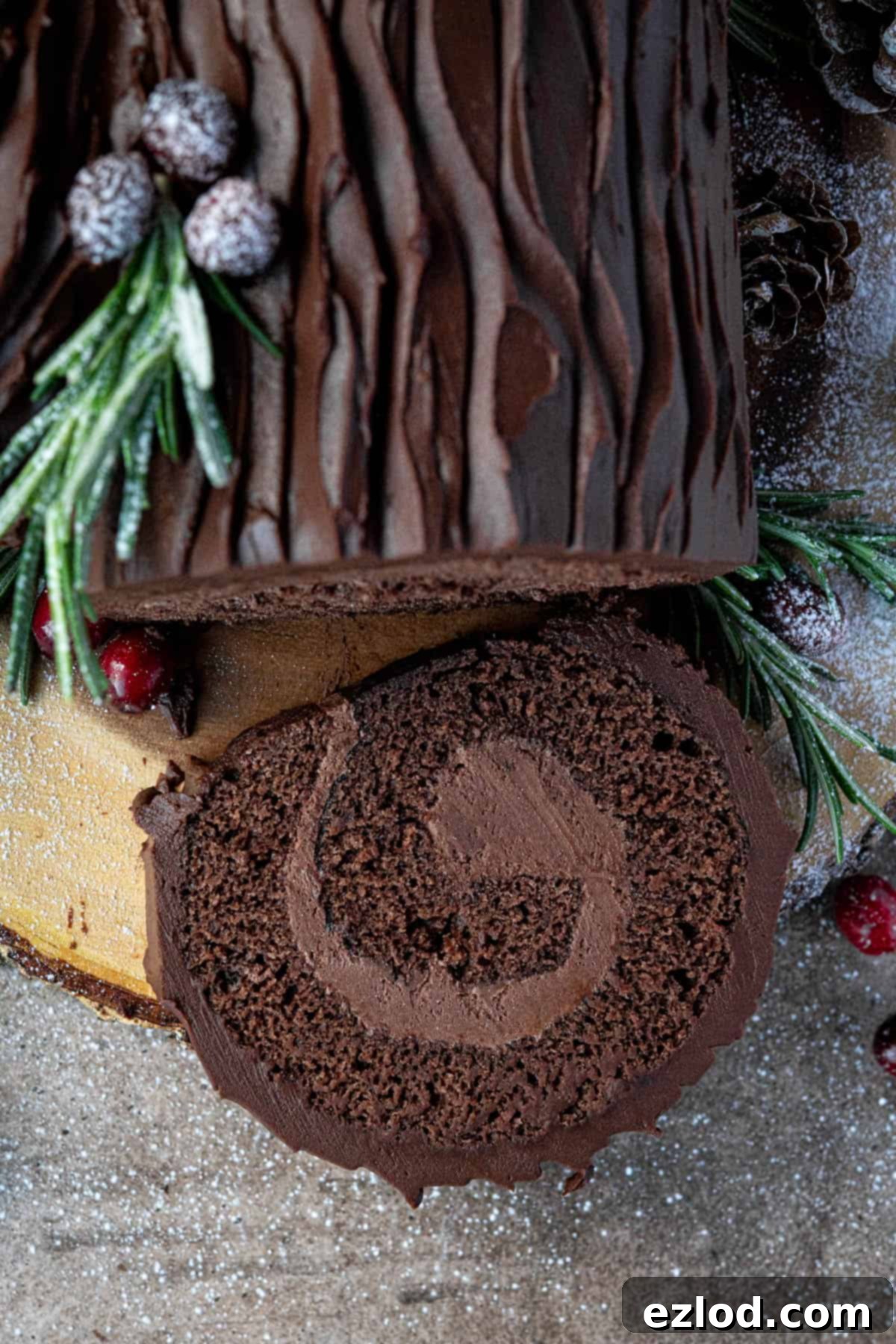 Plant-Based Chocolate Yule Log 4 A close-up shot of a perfect slice of vegan yule log, showing the beautiful spiral of cake and filling, dusted with powdered sugar.