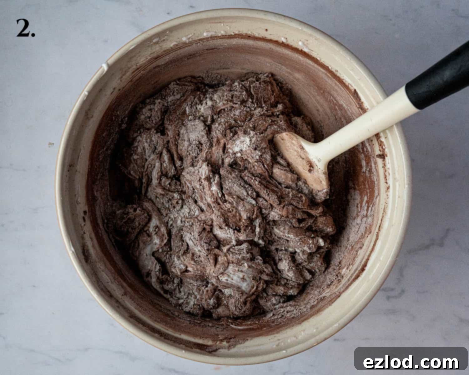 Plant-Based Chocolate Yule Log 6 Step 2: Dry ingredients, including flour and cocoa powder, have been carefully sifted and partially folded into the whipped aquafaba mixture.