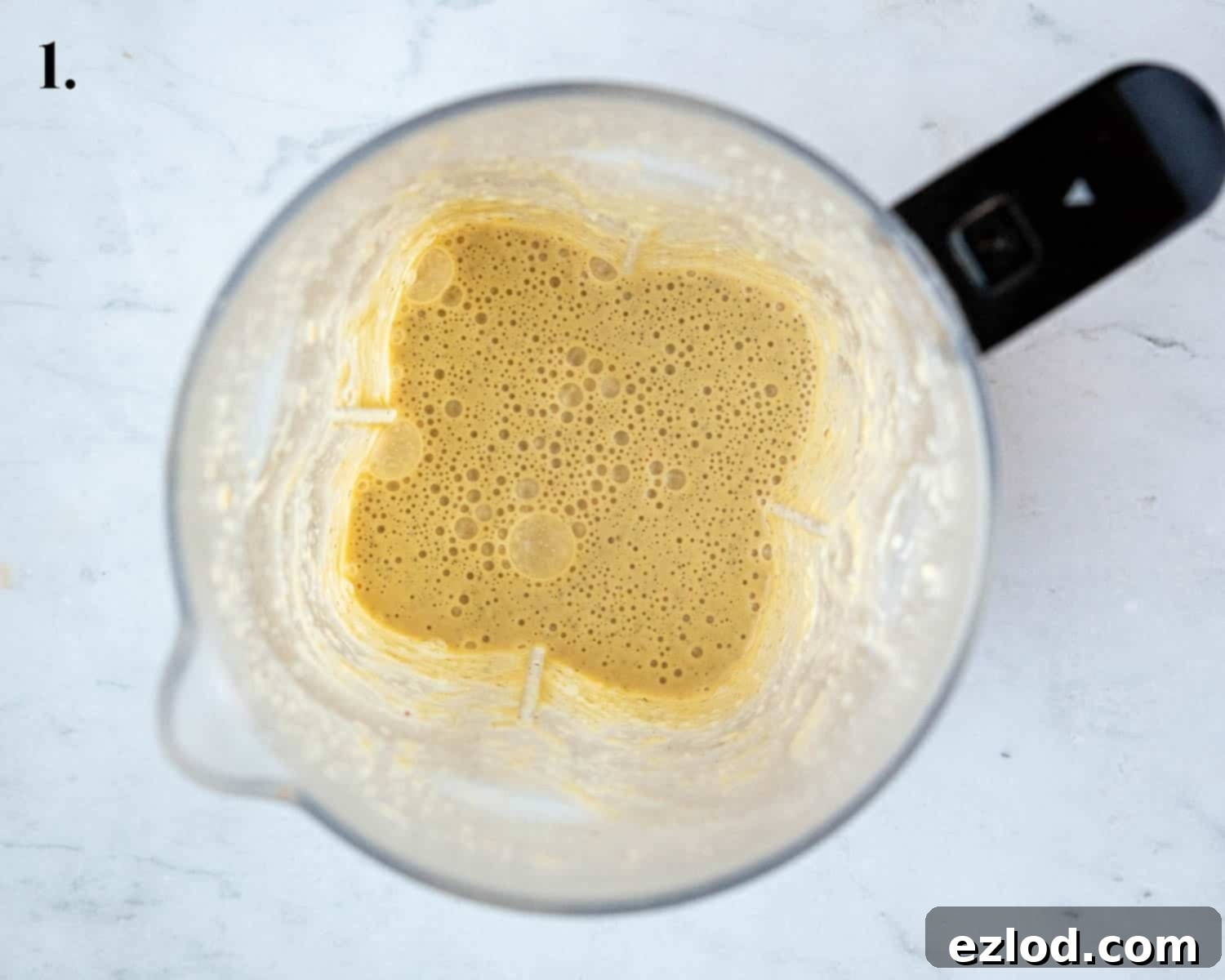 Golden Chickpea Fritters 5 Step 1 in the recipe: A blender jar filled with a smooth, pale yellow batter, ready for cooking.