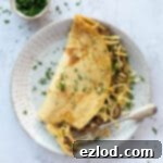 Golden Chickpea Fritters 9 savoury chickpea pancake on a white plate with a forkful removed.