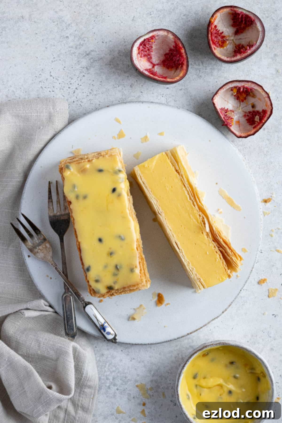 Two vegan vanilla slices on a white plate with dessert forks.