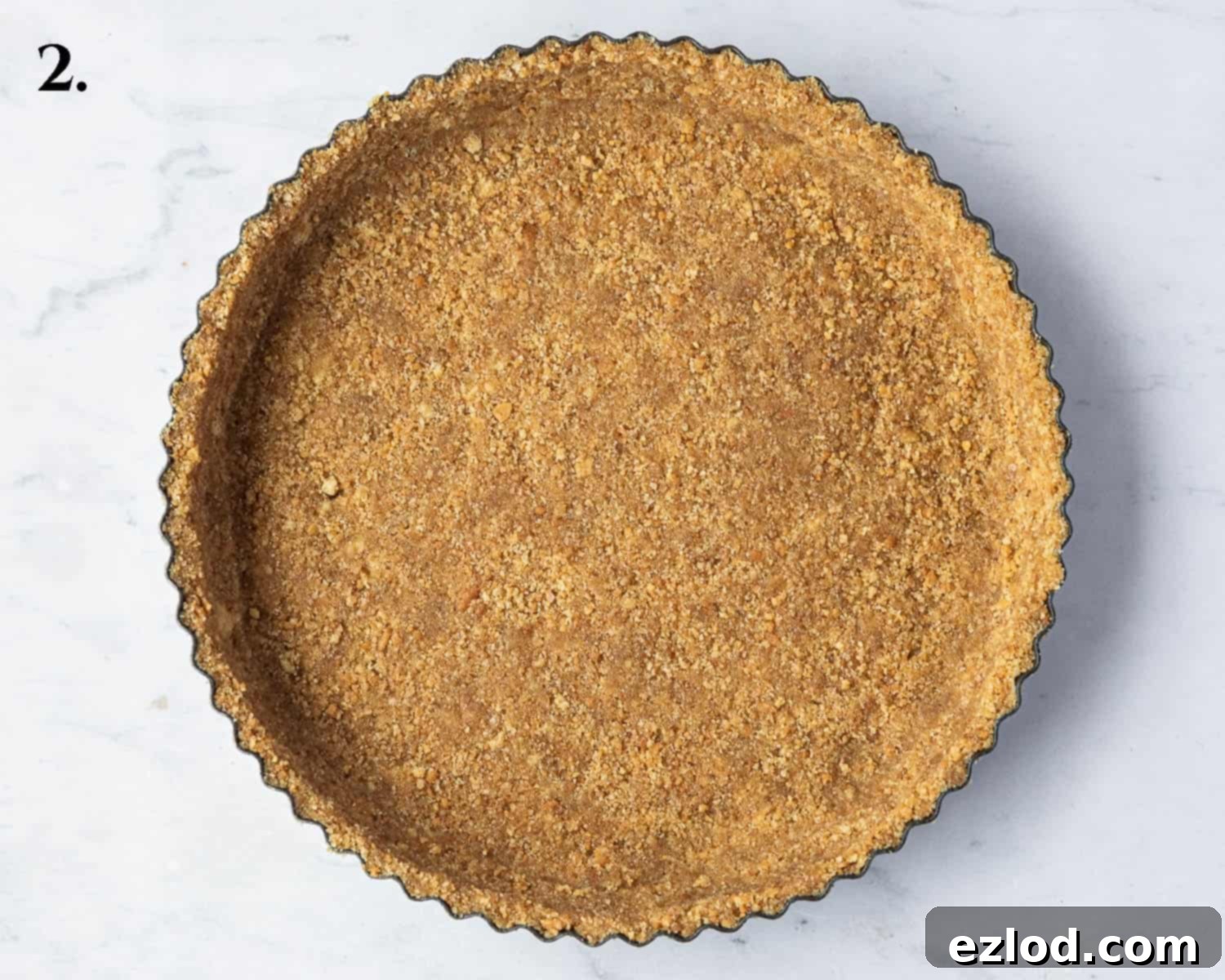 Step 2: A perfectly pressed biscuit base in a tart tin, ready for baking.