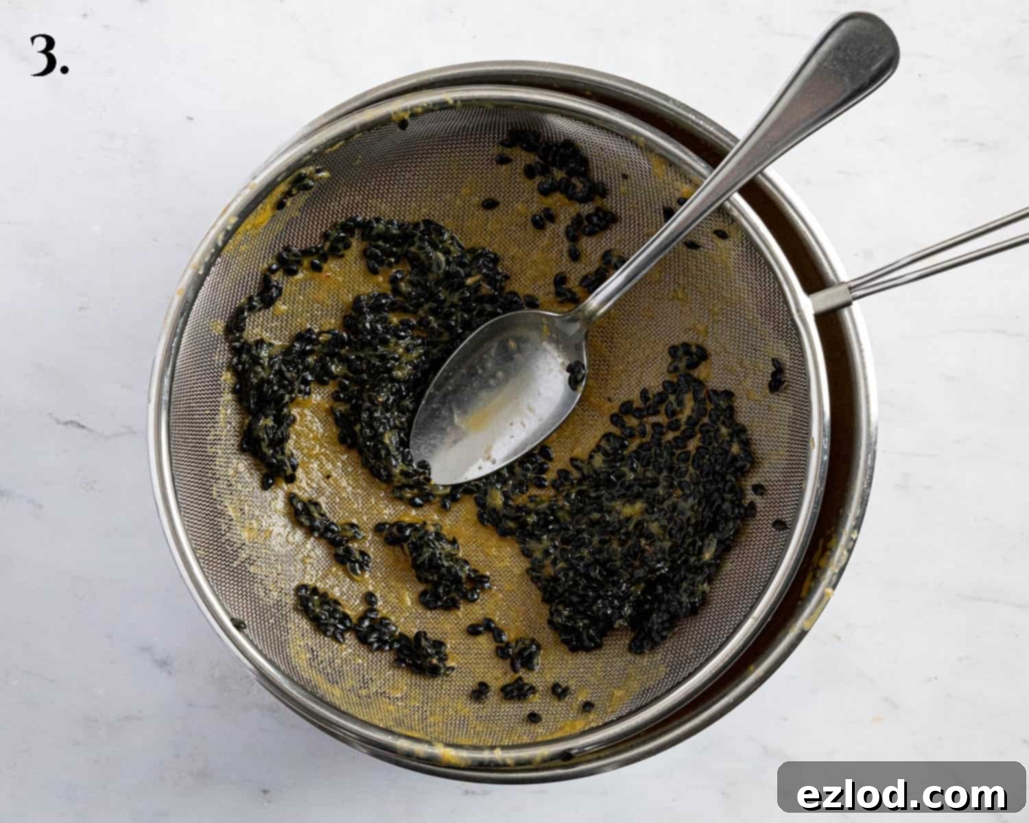 Step 3: Straining passion fruit pulp through a sieve to extract pure juice for the tart filling.