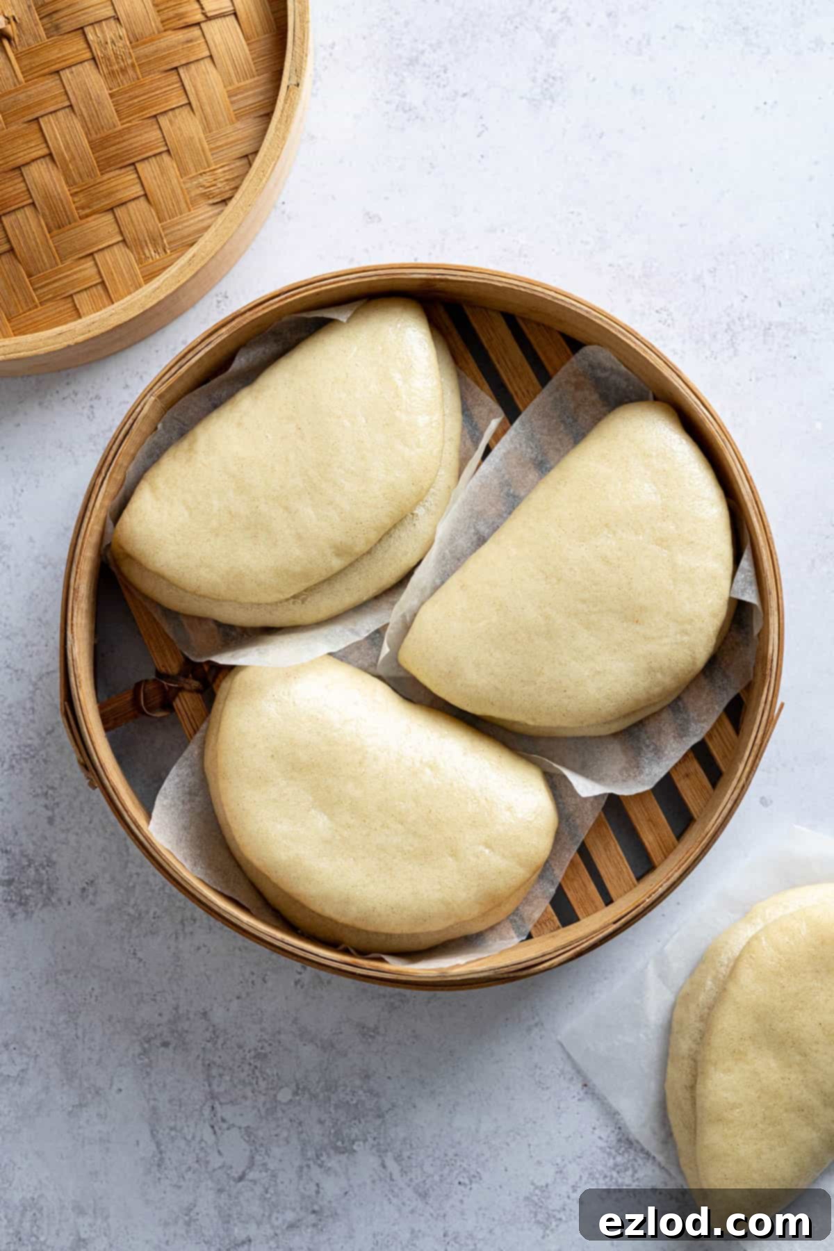 The cooked bao buns still in the bamboo steamer, looking soft and ready.