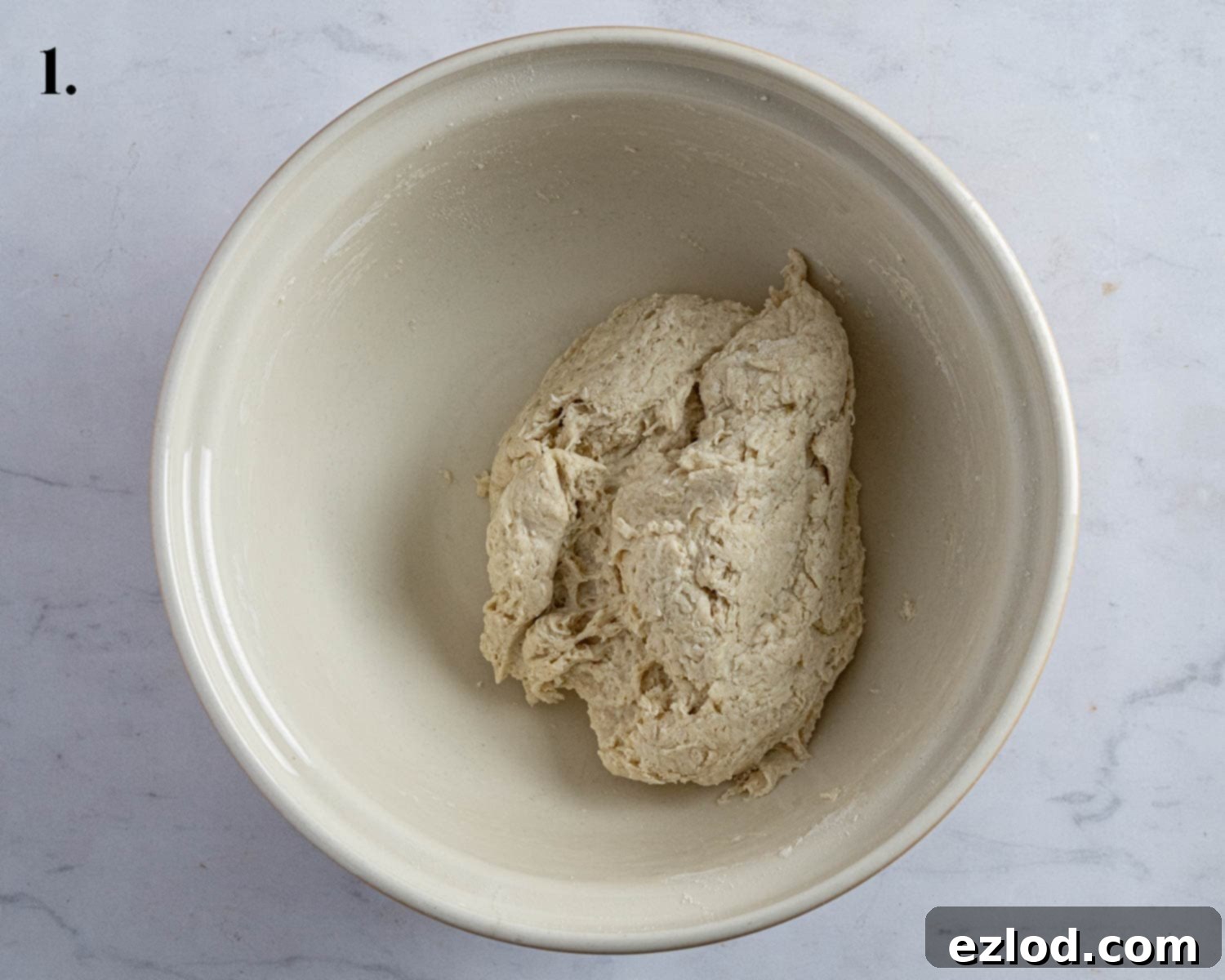 Step 1: The mixed, unkneaded dough for bao buns in a bowl.