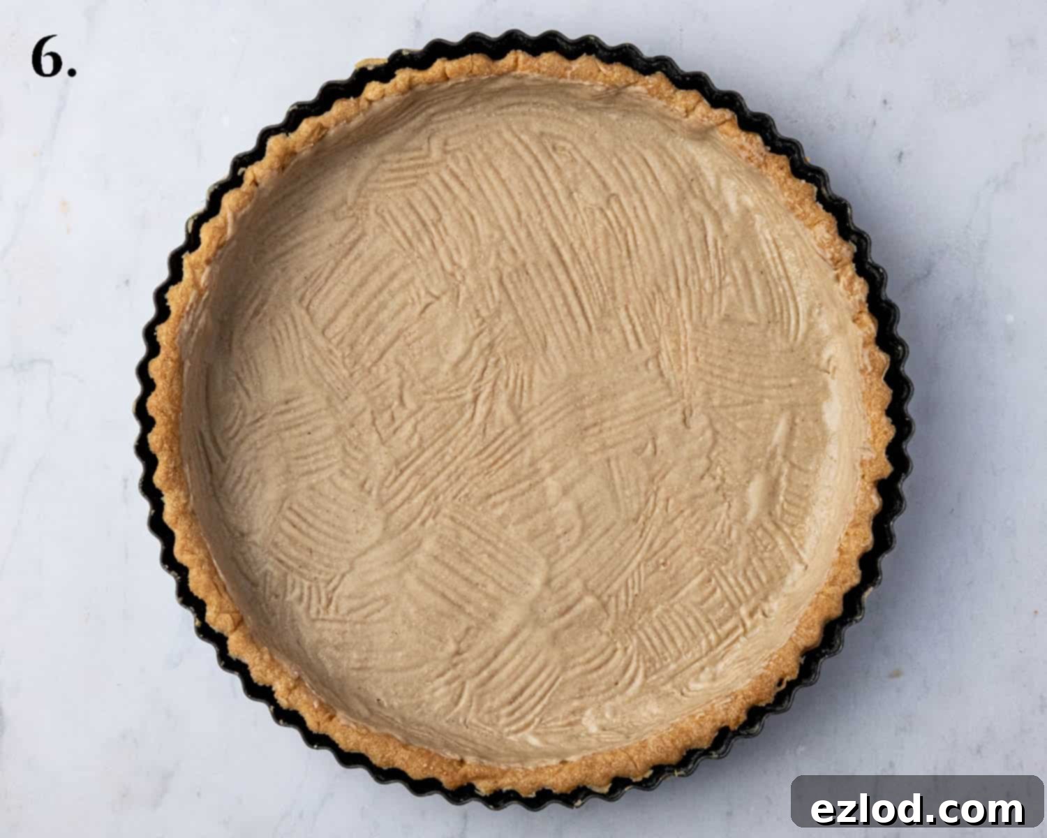 The cooled and blind-baked tart shell, coated internally with a thin, even layer of melted vegan white chocolate.