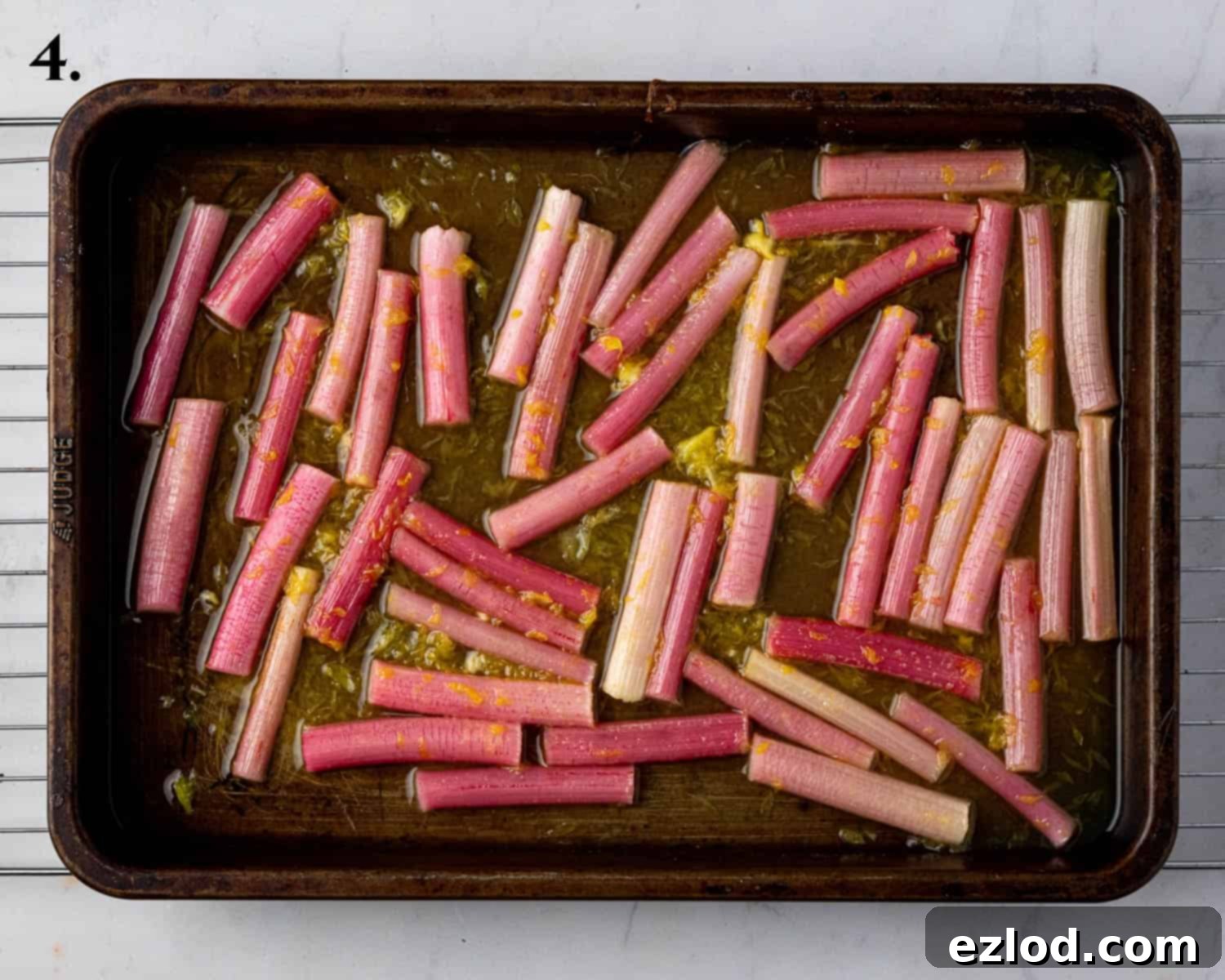 Step 4: Roasted rhubarb pieces arranged on a baking sheet, glistening with orange juice and sugar.