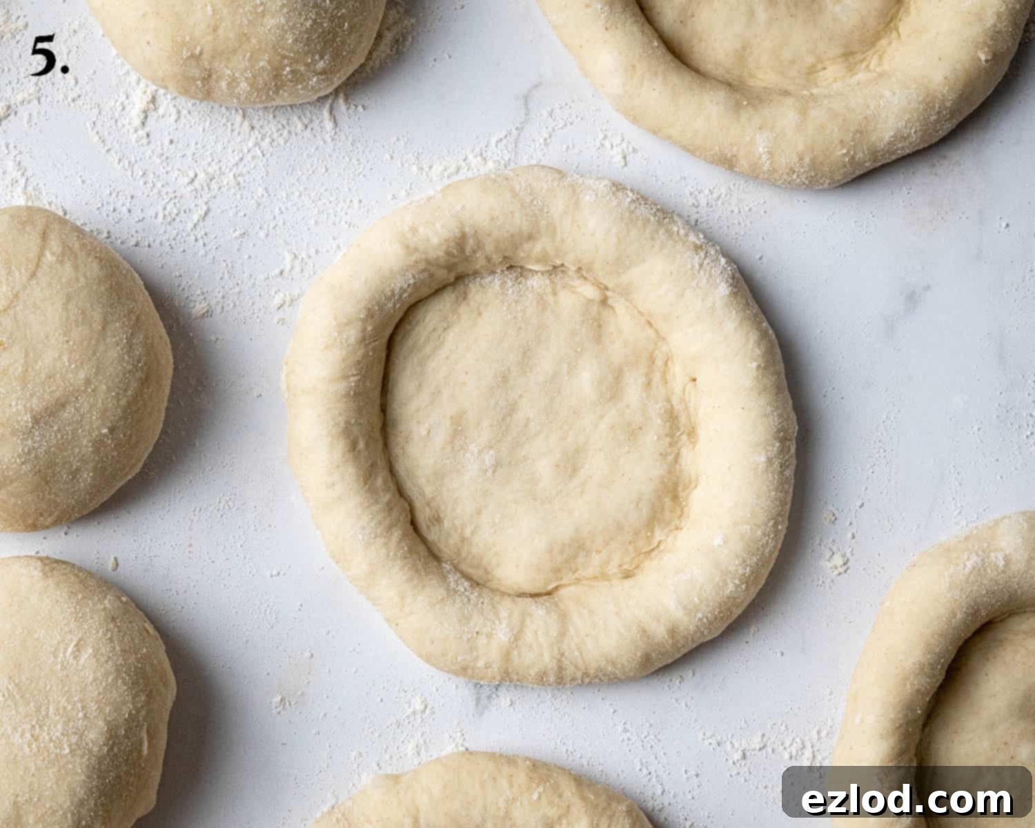 Step 5: The shaped dough portions, flattened into discs with an indentation in the center, ready for their second rise.