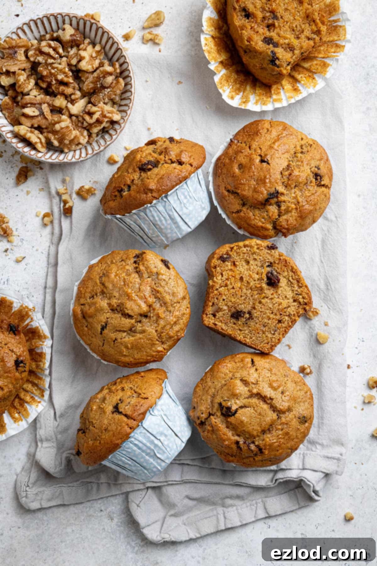 Perfectly Moist Vegan Carrot Muffins 2 Six vegan carrot muffins on a tea towel, one sliced in half.