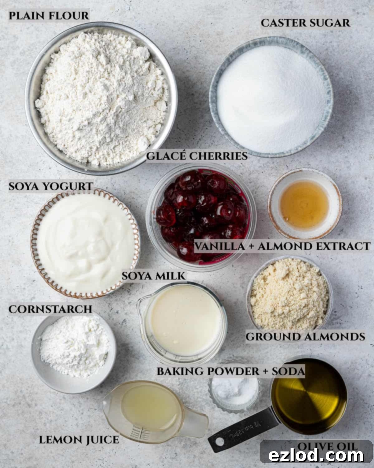 A detailed photo displaying all the essential ingredients meticulously laid out for baking the vegan cherry loaf cake, including flour, sugar, cherries, almonds, and liquid components.