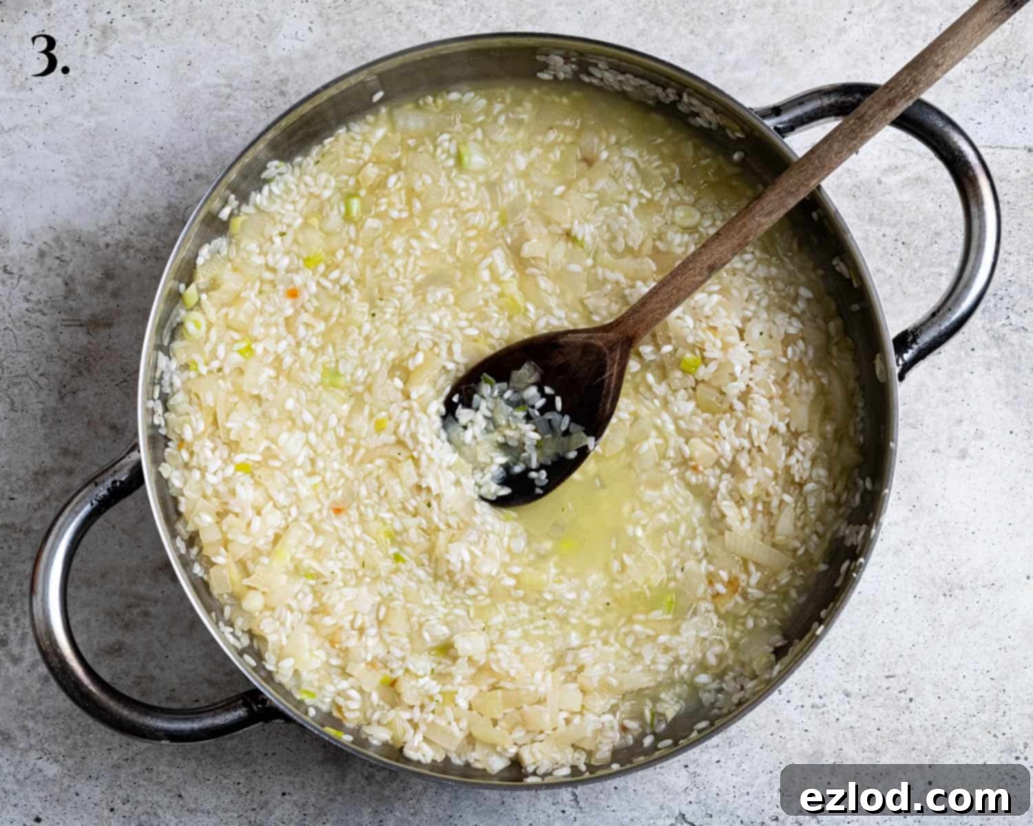 Step 3: Risotto rice absorbing white wine in a pan, before the gradual addition of vegetable stock.