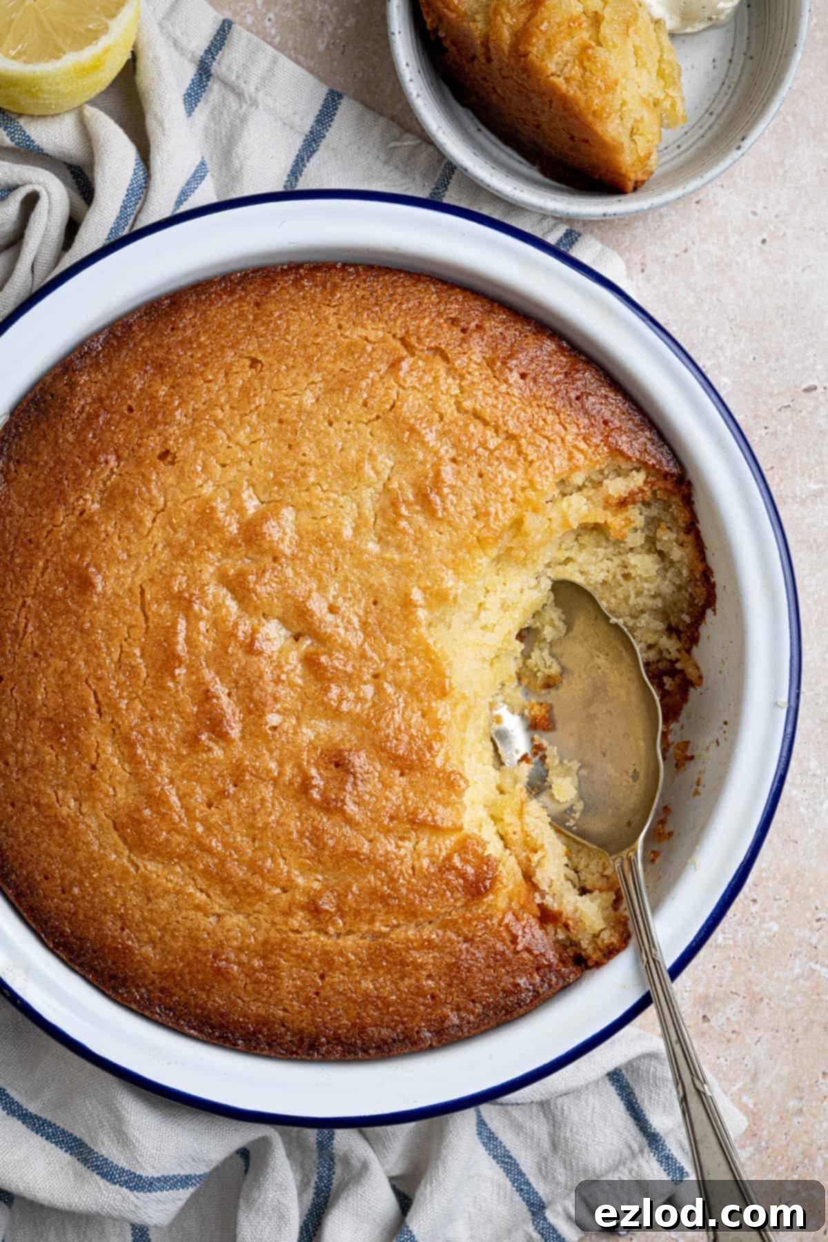 A close-up of a spoonful of lemon elderflower almond pudding lifted from the dish, showcasing its moist texture and delicate crumb.
