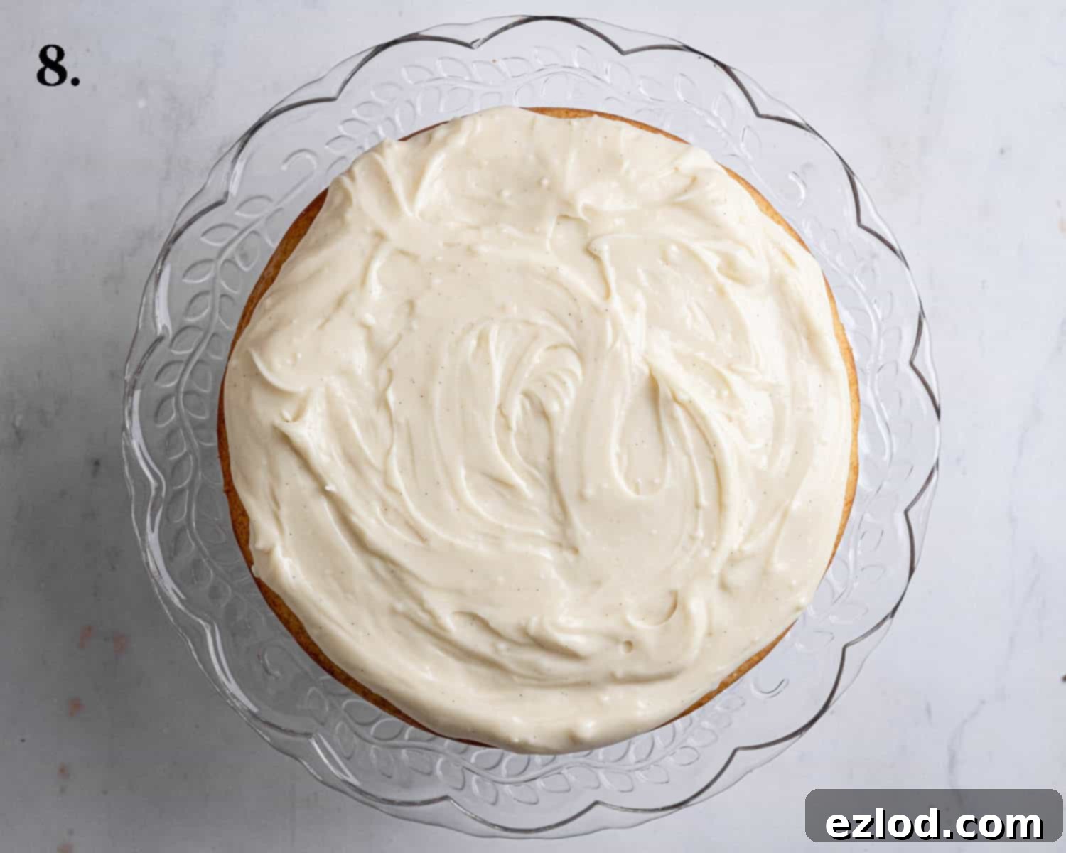 Step 8 of making vegan Boston cream pie: The first cake layer beautifully spread with a generous, creamy layer of chilled vegan pastry cream.
