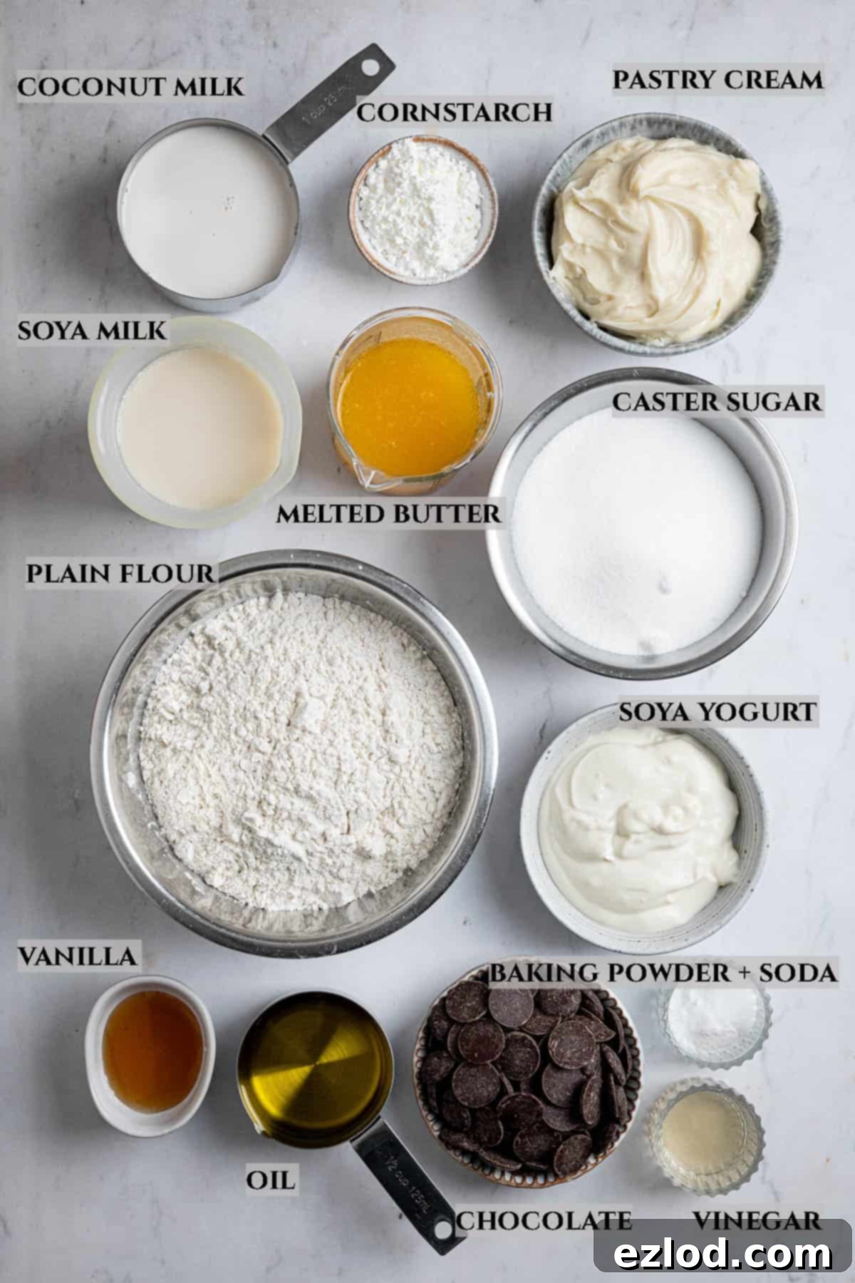 A labelled photo displaying all the essential ingredients for making vegan Boston cream pie, neatly arranged in separate bowls for clarity.