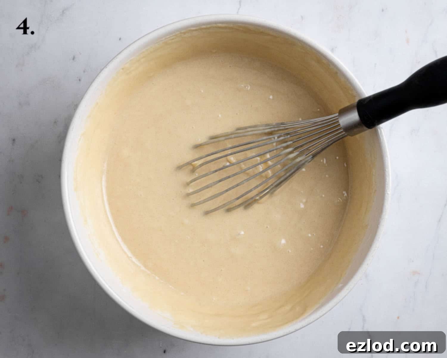 Step 4 of making vegan Boston cream pie: The perfectly combined cake batter in a bowl, showing a smooth, consistent texture.