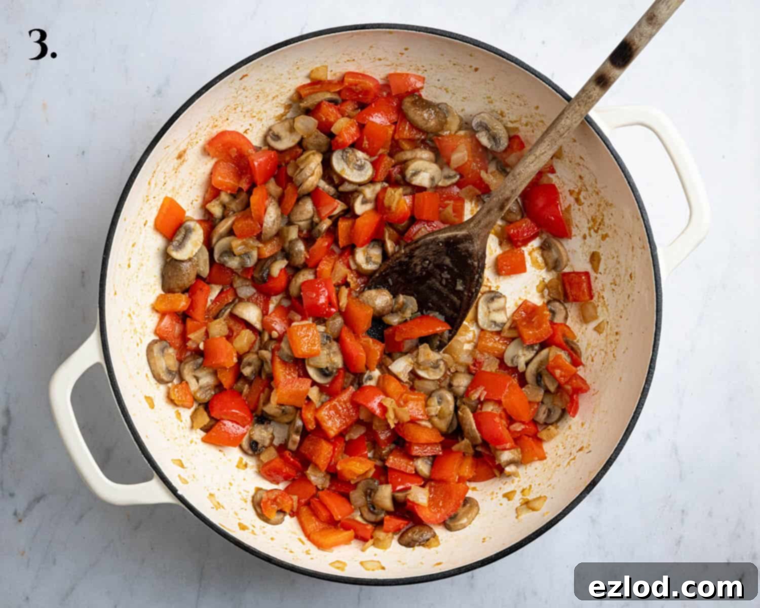 Step 3: Sautéed onions, peppers, mushrooms, and garlic cooking in a pan.