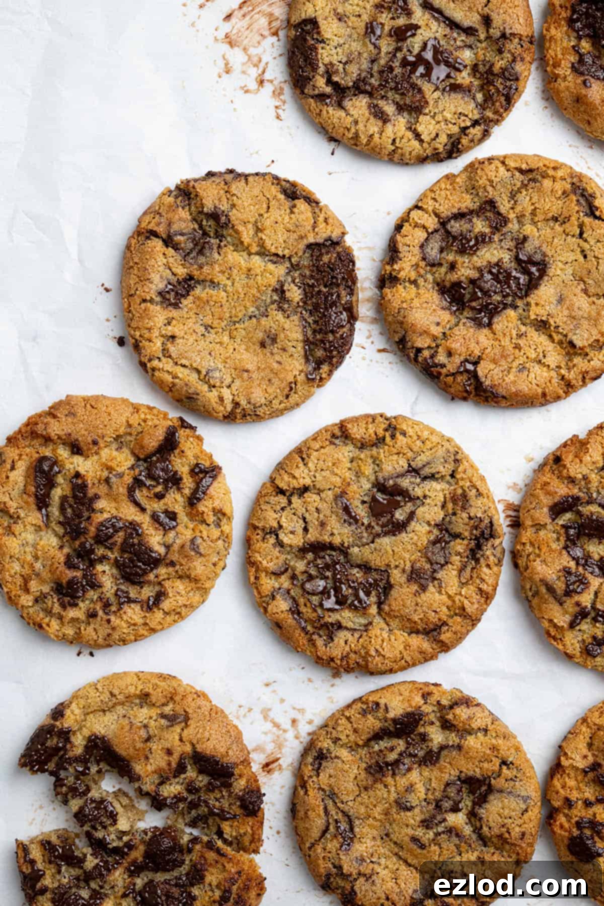 Several vegan air fryer chocolate chip cookies arranged neatly on a sheet of baking paper.