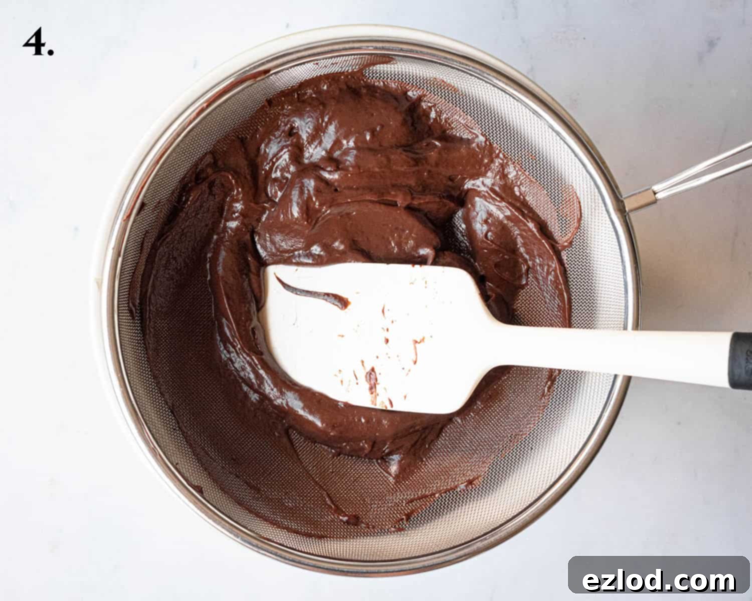 Step 4, scraping the pastry cream through a sieve.
