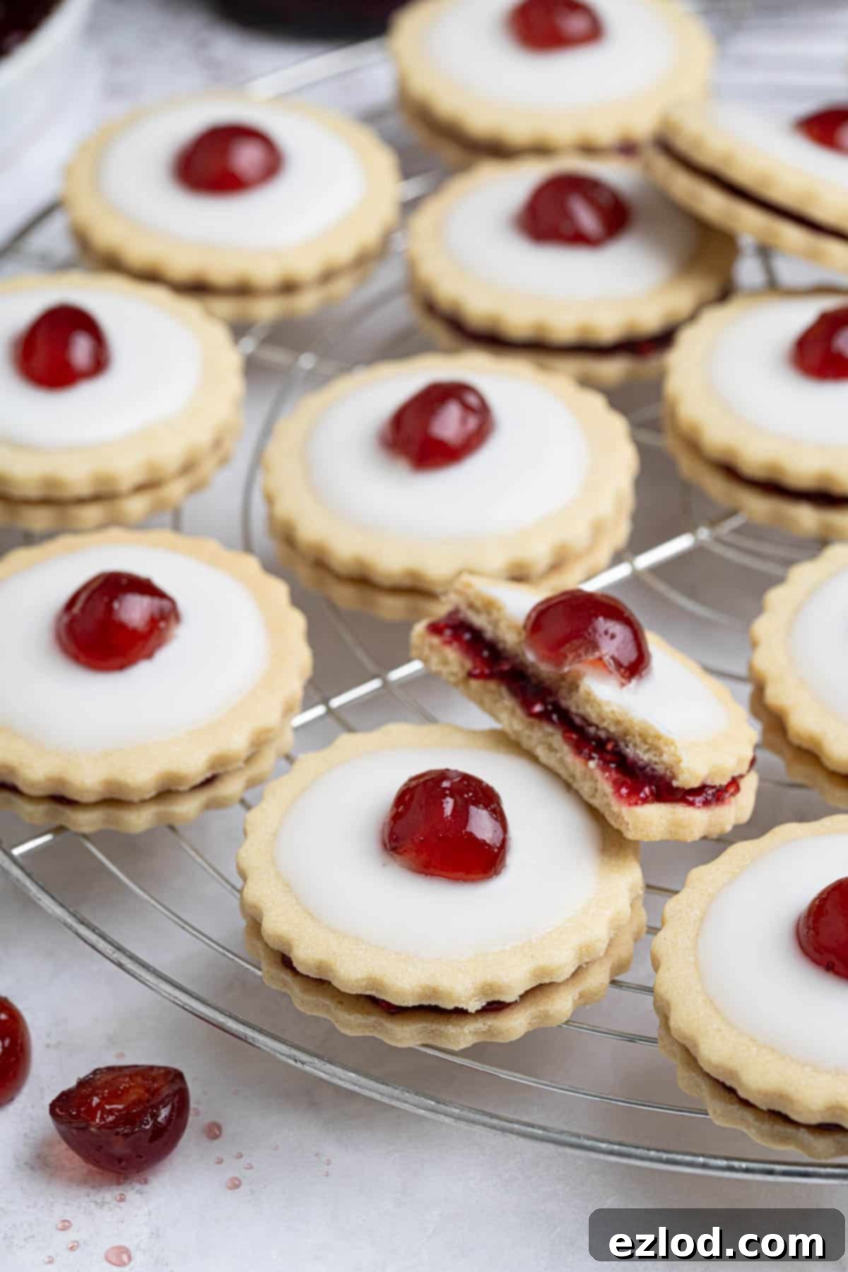 Close up of vegan empire biscuits on a cooling rack, one broken in half.