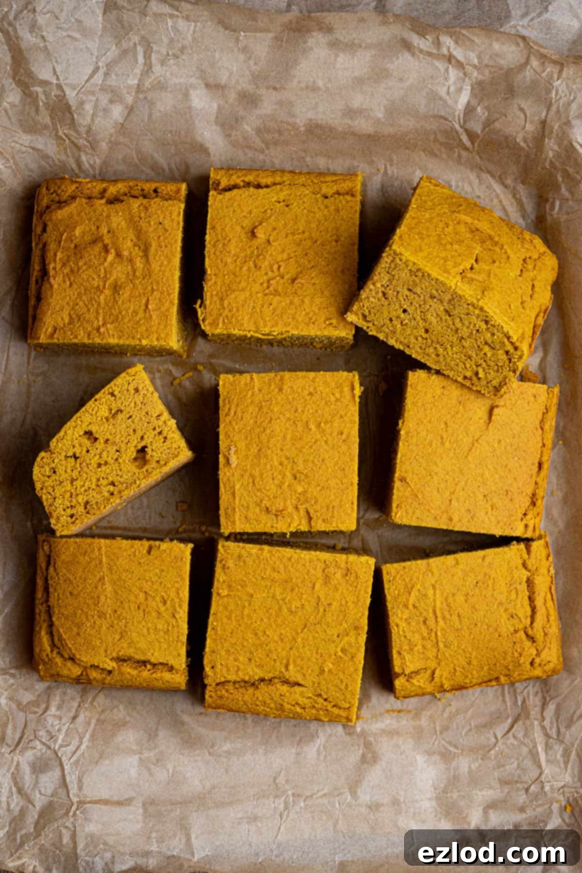 Golden Harvest Vegan Cornbread 9 Squares of vegan pumpkin cornbread on a sheet of baking paper.