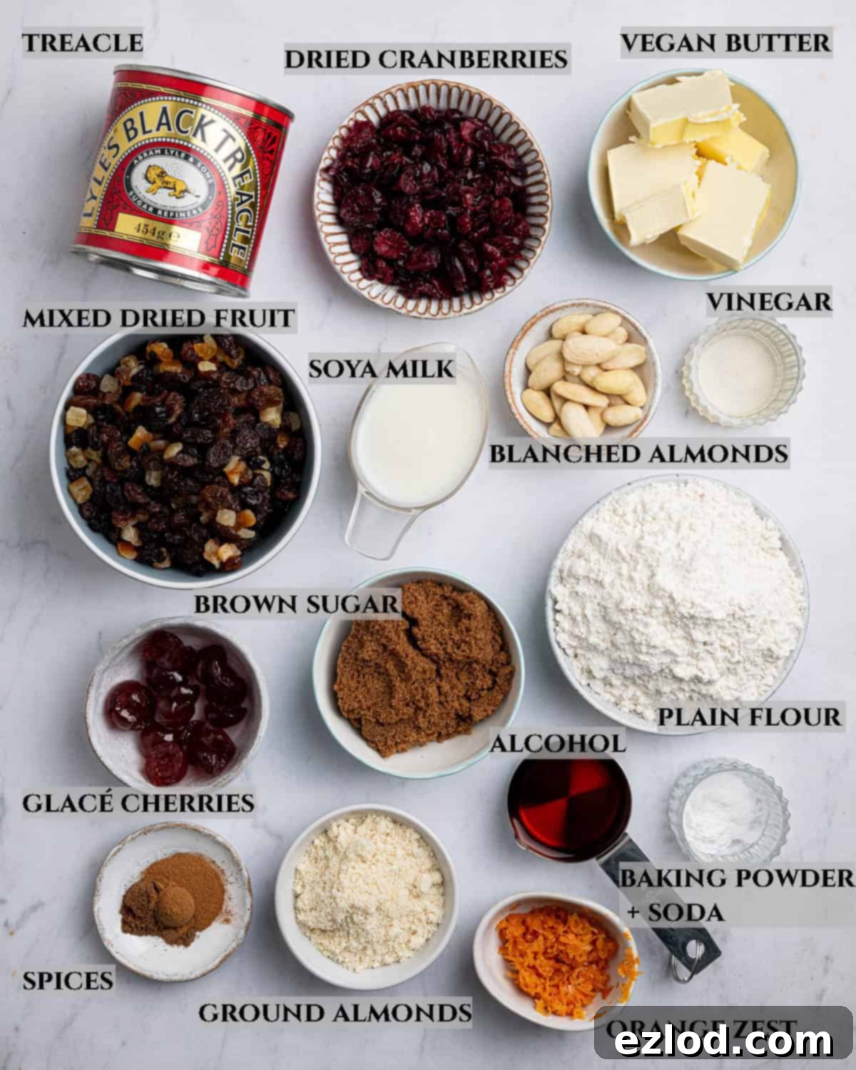 A labelled photo of the ingredients needed to make small batch vegan Christmas cake, in bowls.