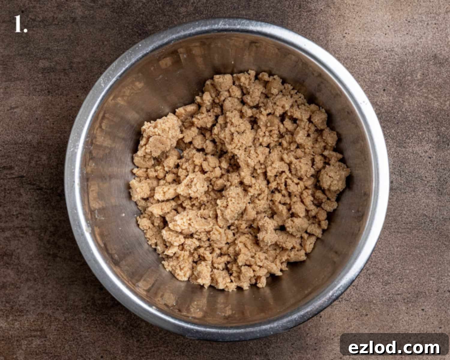 Spiced Pear Plant-Based Muffins 5 Step-by-step image showing the streusel mixture in a bowl, with ingredients combined into a crumbly texture.