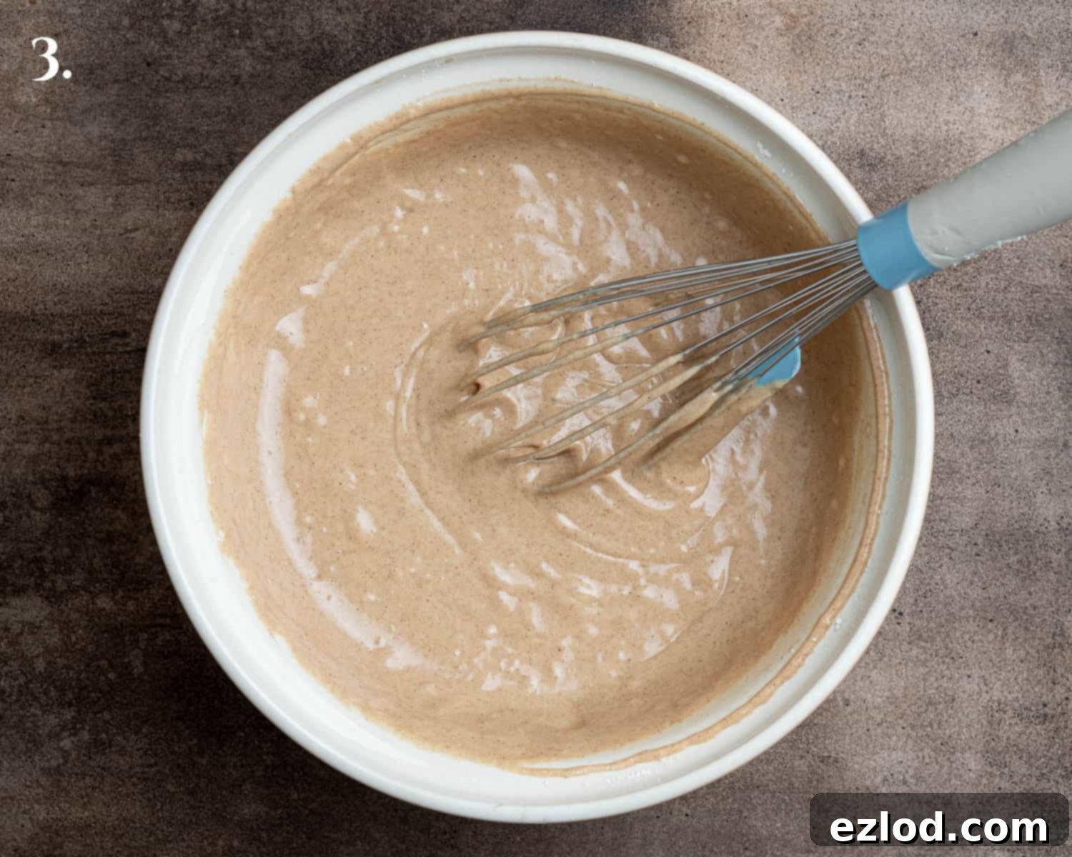 Spiced Pear Plant-Based Muffins 7 Step-by-step image showing the fully combined muffin batter in a bowl, before adding the pears.