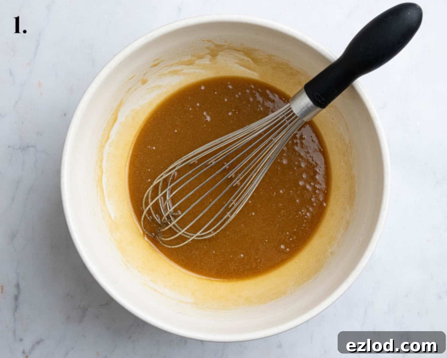 Step 1: The wet ingredients, including melted vegan butter, brown sugar, milk, and vanilla extract, are whisked together in a bowl.