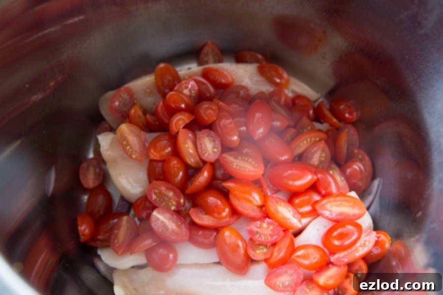 Chicken in Instant Pot topped with tomatoes 
