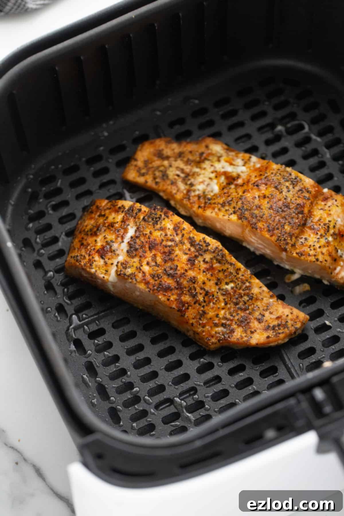 Cooked Air Fryer Salmon in an Air Fryer Basket. 