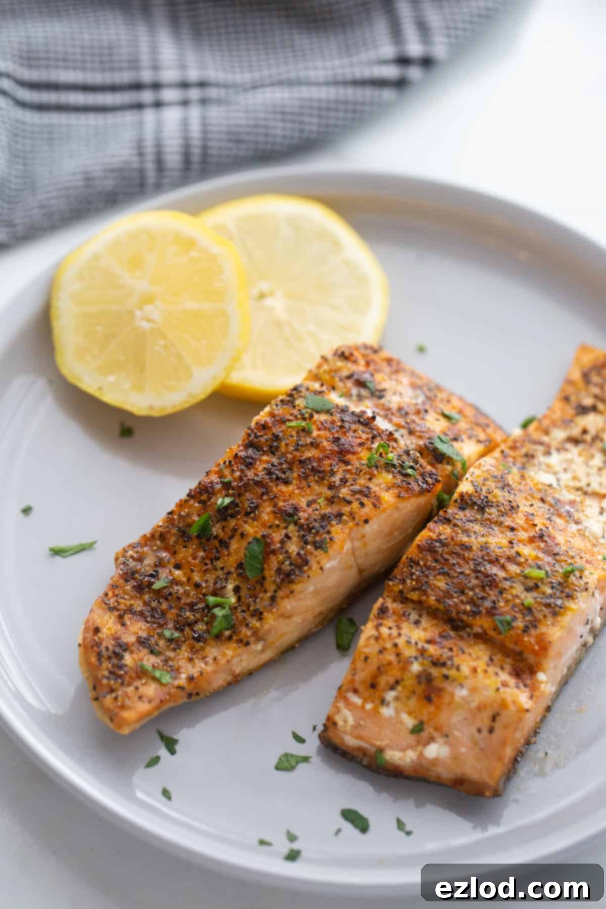 Perfectly cooked salmon fillets made in the air fryer garnished with fresh herbs. 