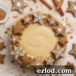 Vegan gingerbread cheesecake surrounded by gingerbread cookies and cinnamon sticks.
