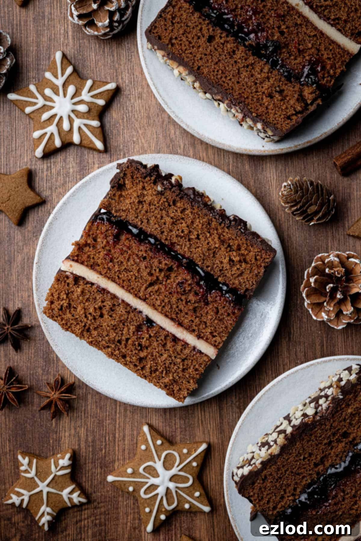 Three perfectly cut slices of Vegan Piernik, each showcasing the beautiful jam and marzipan layers, presented on elegant white plates.